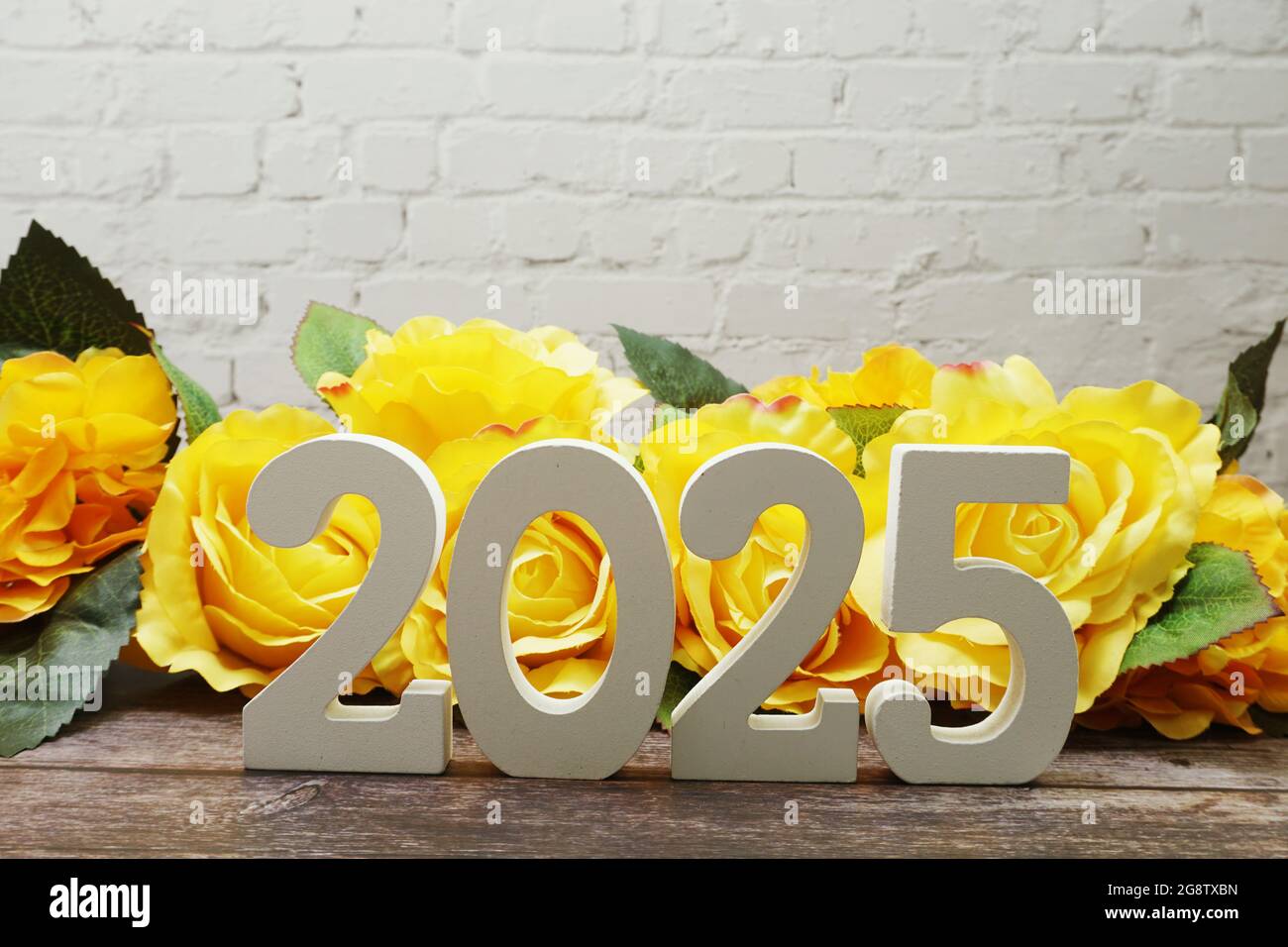 2025 Happy New Year with Roses Flower Decoration with space copy on white brick wall Stock Photo