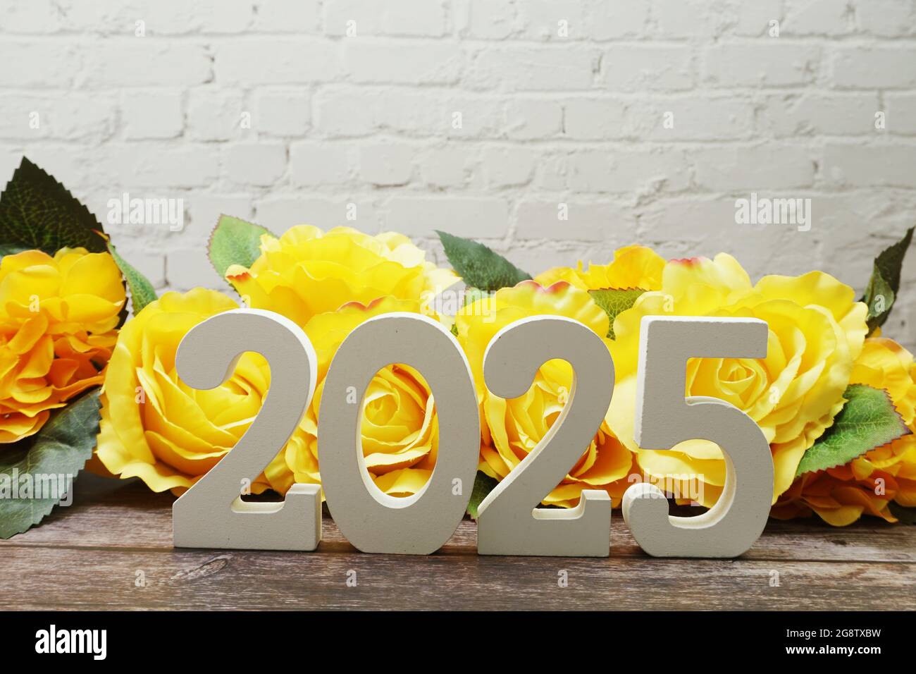 2025 Happy New Year with Roses Flower Decoration with space copy on white brick wall Stock Photo