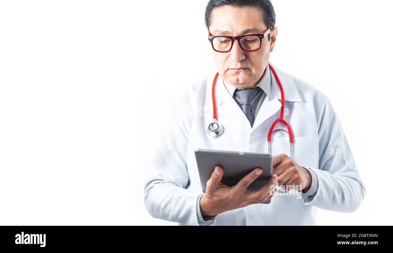 Front tom of doctor in gown, stethoscope and tie reviewing information or diagnosis on a tablet on white background. Medicine and technology concept. Stock Photo