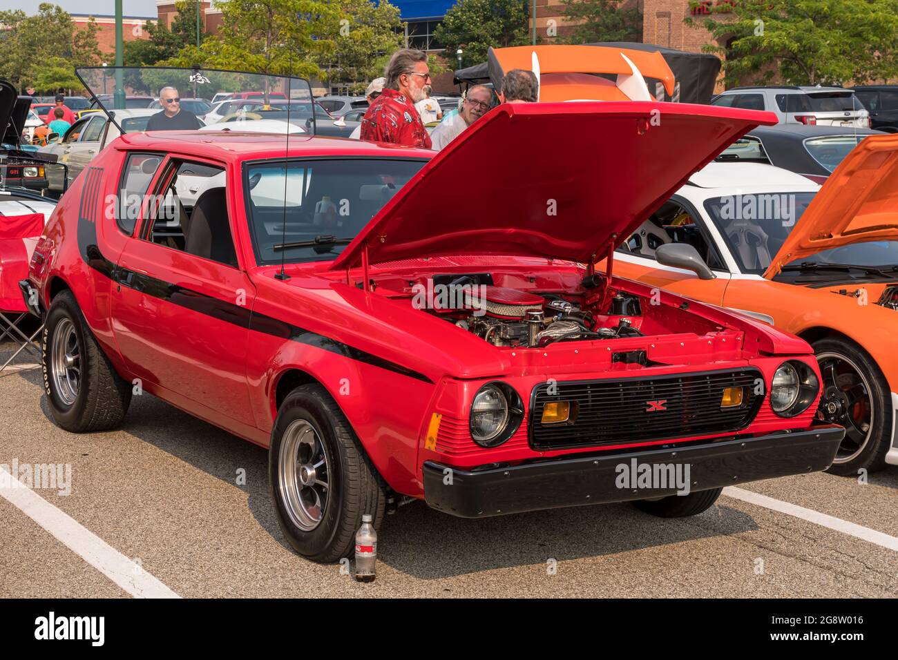 A 1977 red with black stripes AMC Gremlin with a modified motor and it's hood open at a summer vintage car show in Homestead, Pennsylvania, USA Stock Photo