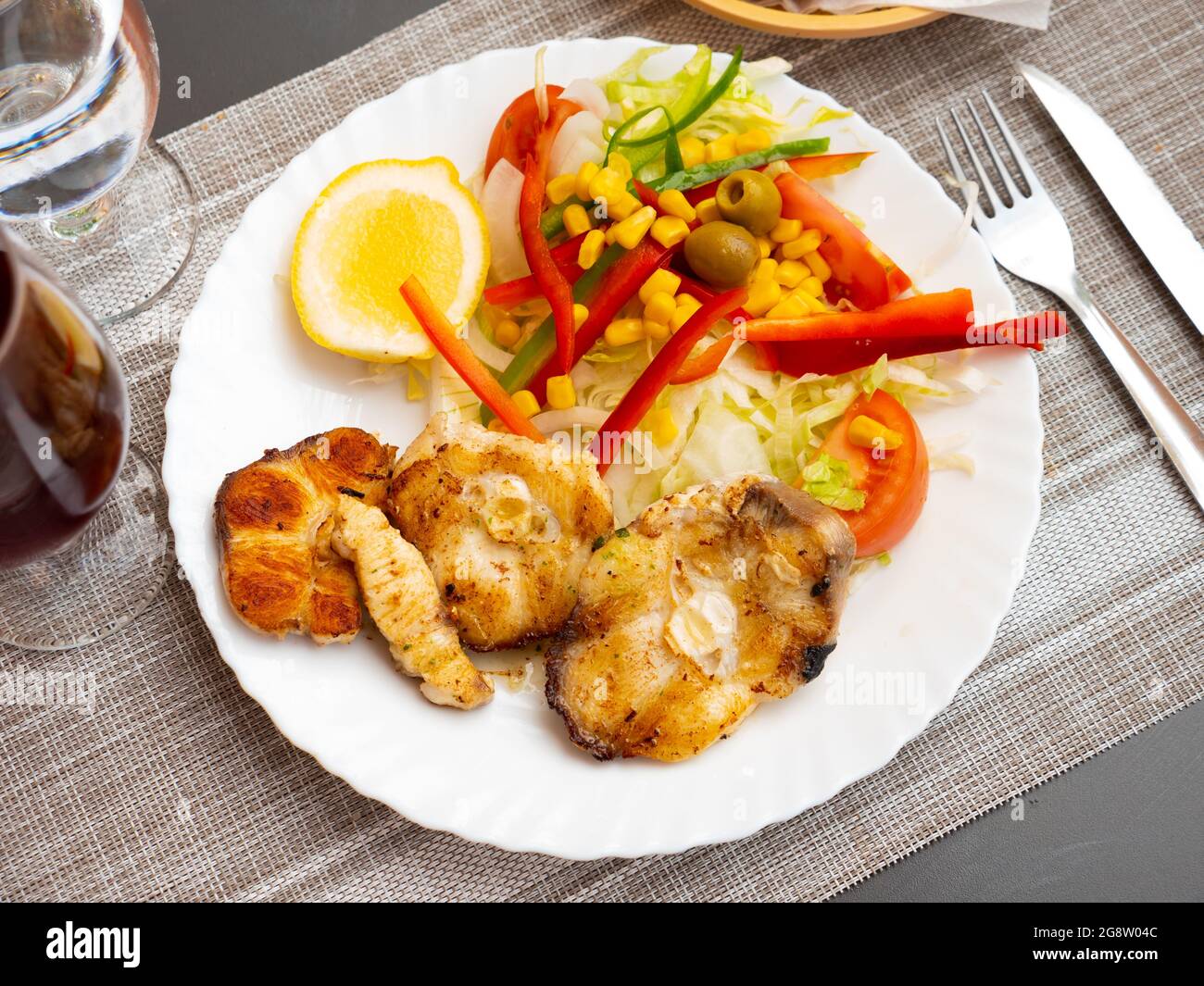 Oven baked hake with vegetable garnish Stock Photo
