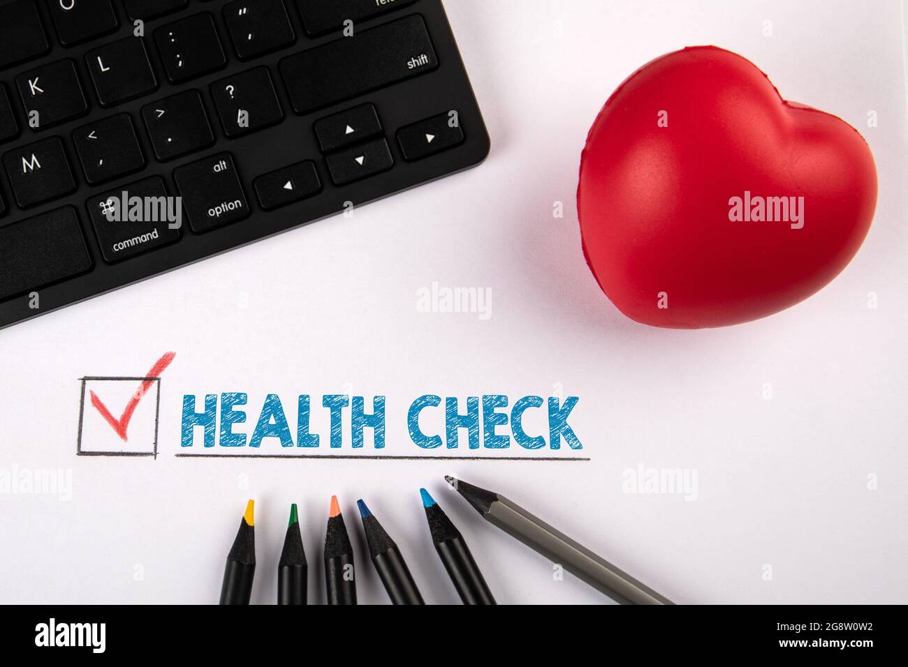 Health Check. Red rubber heart and black computer keyboard on a white