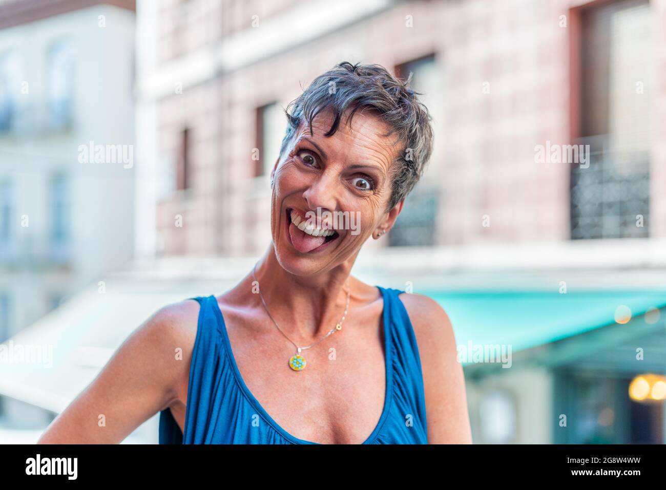 Portrait of a funny short hair mature woman on the street doing funny faces Stock Photo