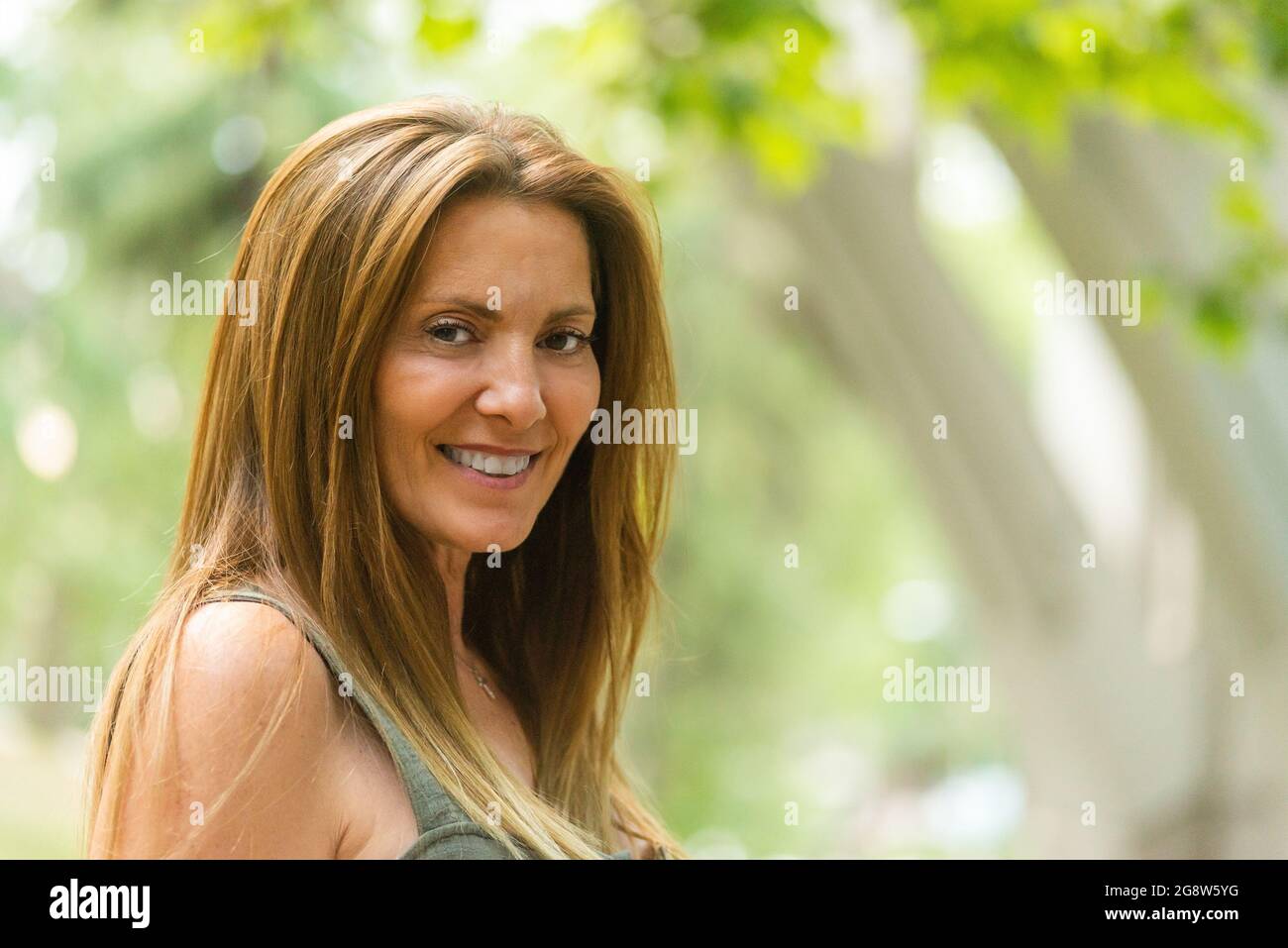 Long hair mature woman smiling looking at camera Stock Photo