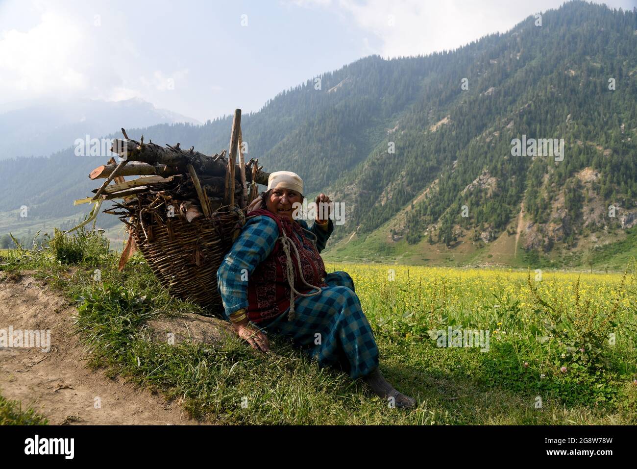 Bandipora India 23rd July 2021 A Dard Woman Rests While Carrying A Basket Full Of Fire Wood Walks In An Open Field In Dawar Gurez Gurez Lies Along The Loc Line Of Control