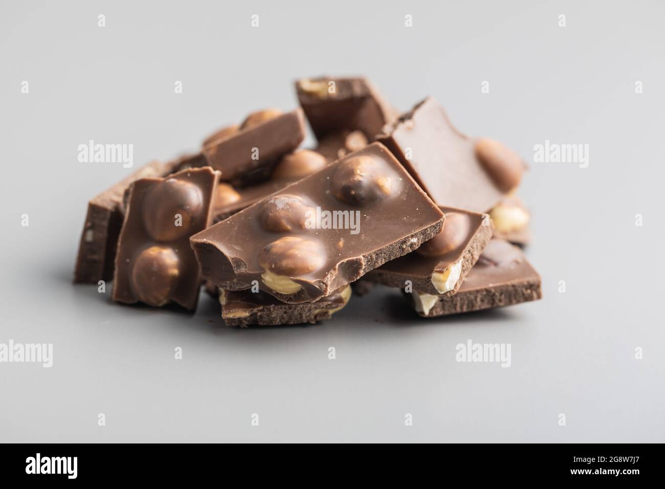 Nutty chocolate with hazelnuts on gray background. Stock Photo