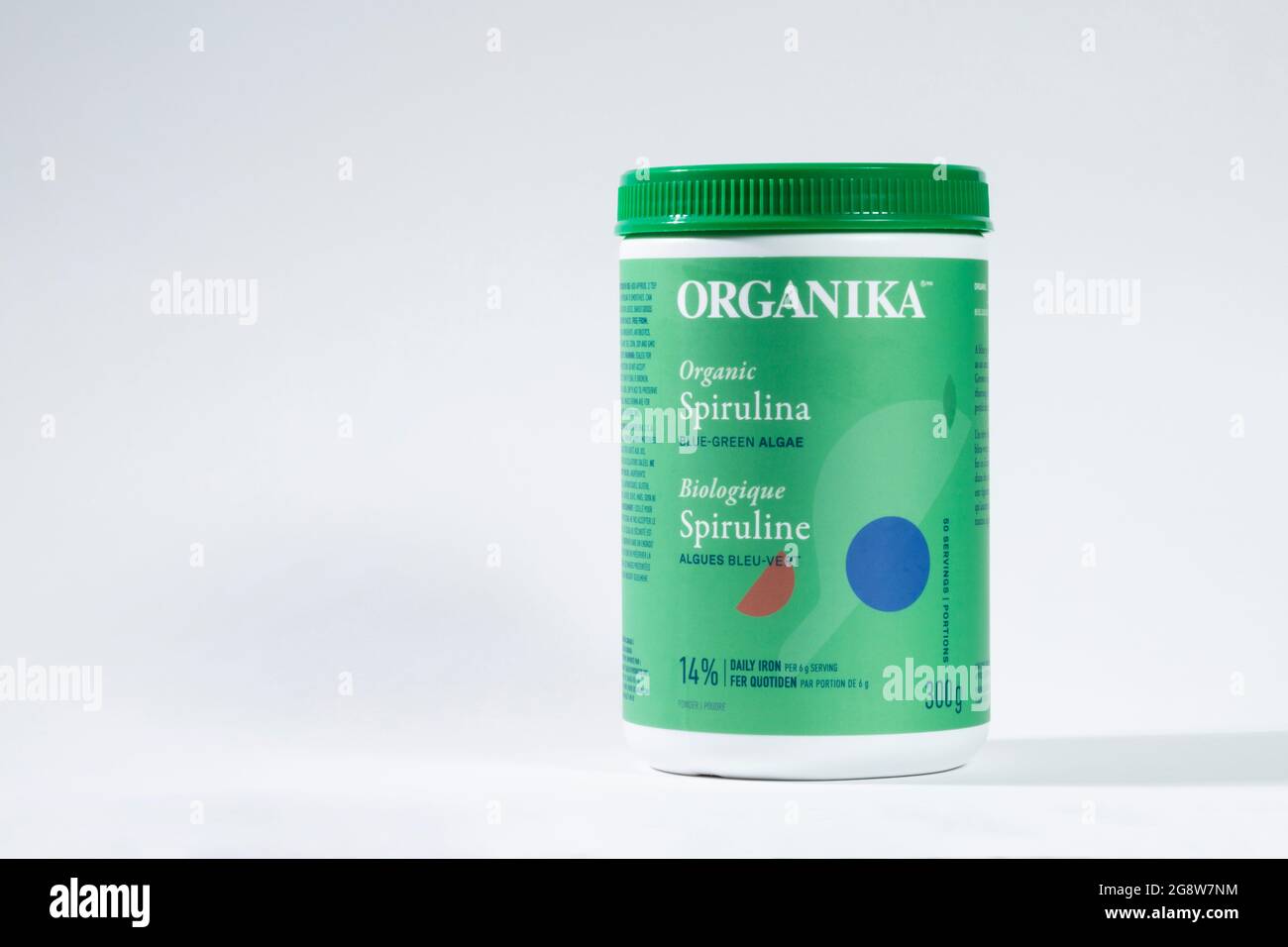 Organic Spirulina powder is in a sealed package container. Organika brand Spirulina powder isolated on white background. Stock Photo