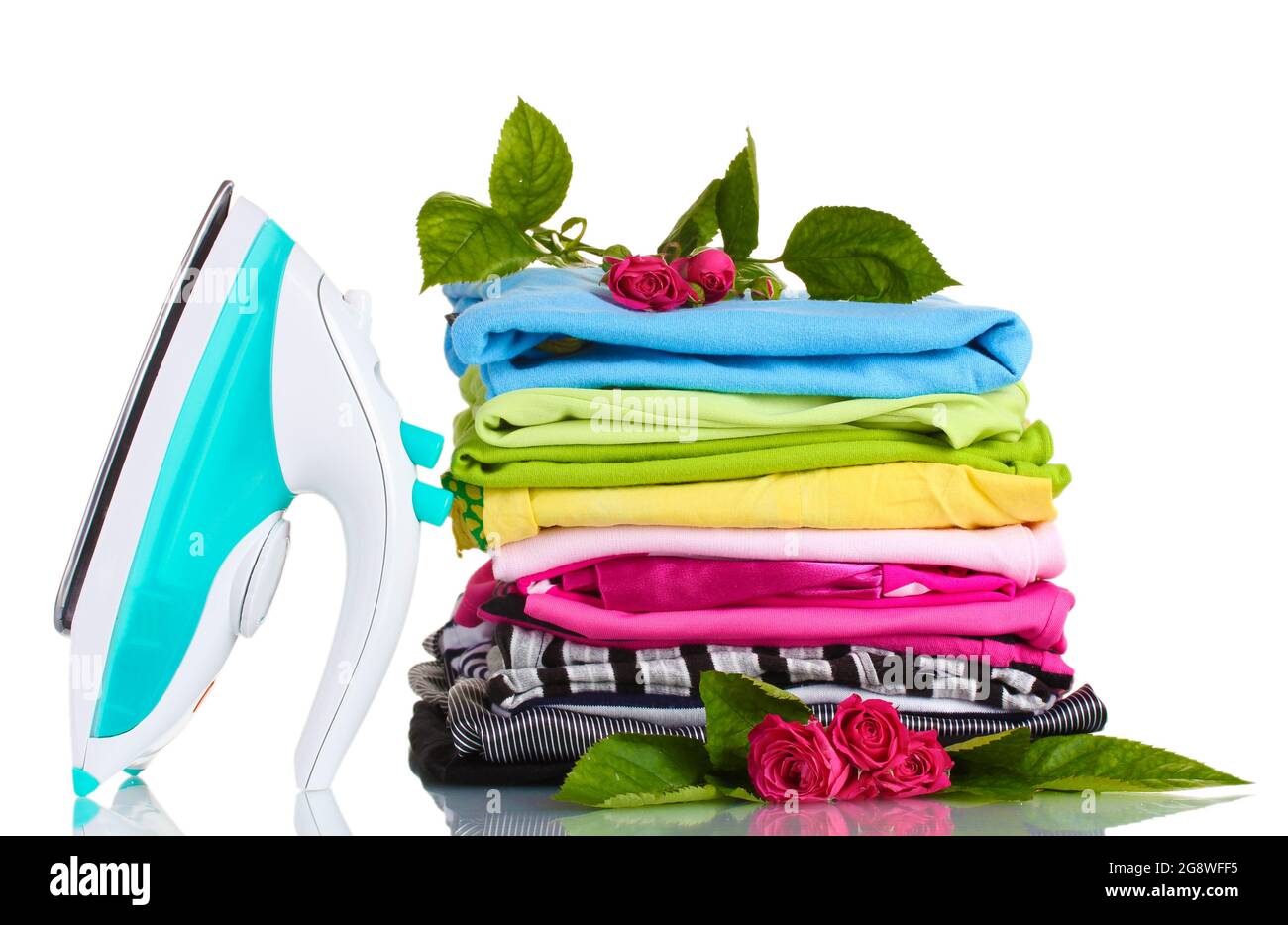 pile-of-colorful-clothes-and-electric-iron-with-roses-isolated-on-white