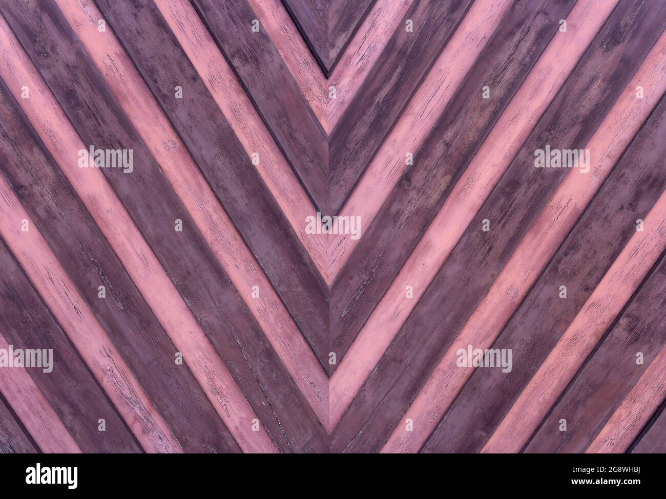 Detail of a wooden wall with pointed striped pattern in pink and purple Stock Photo