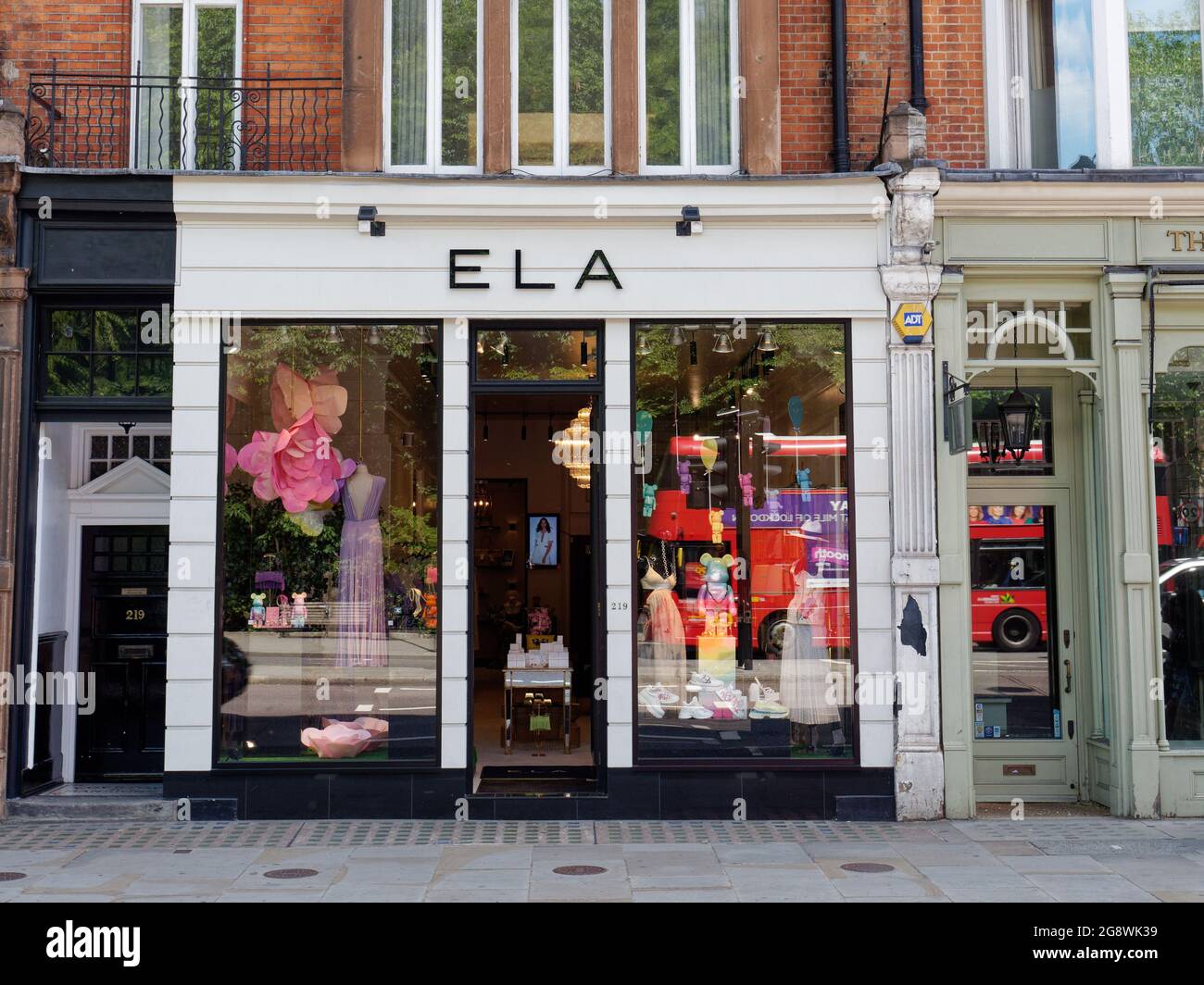 London, Greater London, England, June 12 2021: Red bus reflecting in the window of Ela fashion clothing store in Knightsbridge. Stock Photo