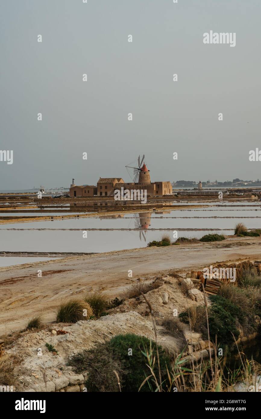 Saline of the Laguna Marsala,Sicily,Italy.Nature reserve with beautiful windmills,brine pools shimmering with different colors,traditional production Stock Photo