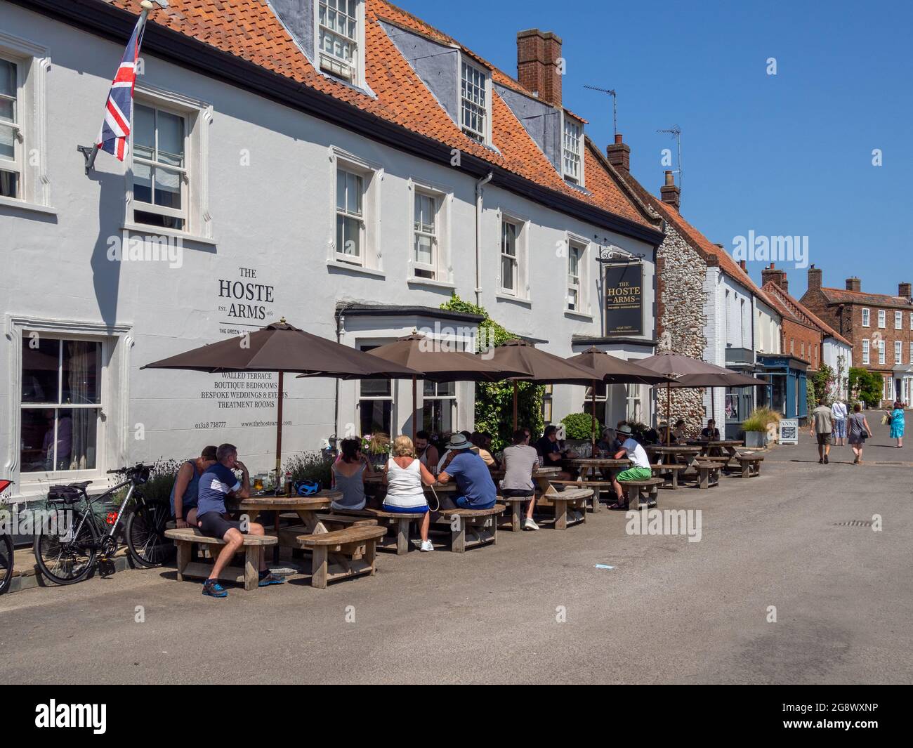 Diners eating al fresco on a warm summer day at the Hoste Arms, a popular pub in Burnham Market, Norfolk, UK Stock Photo