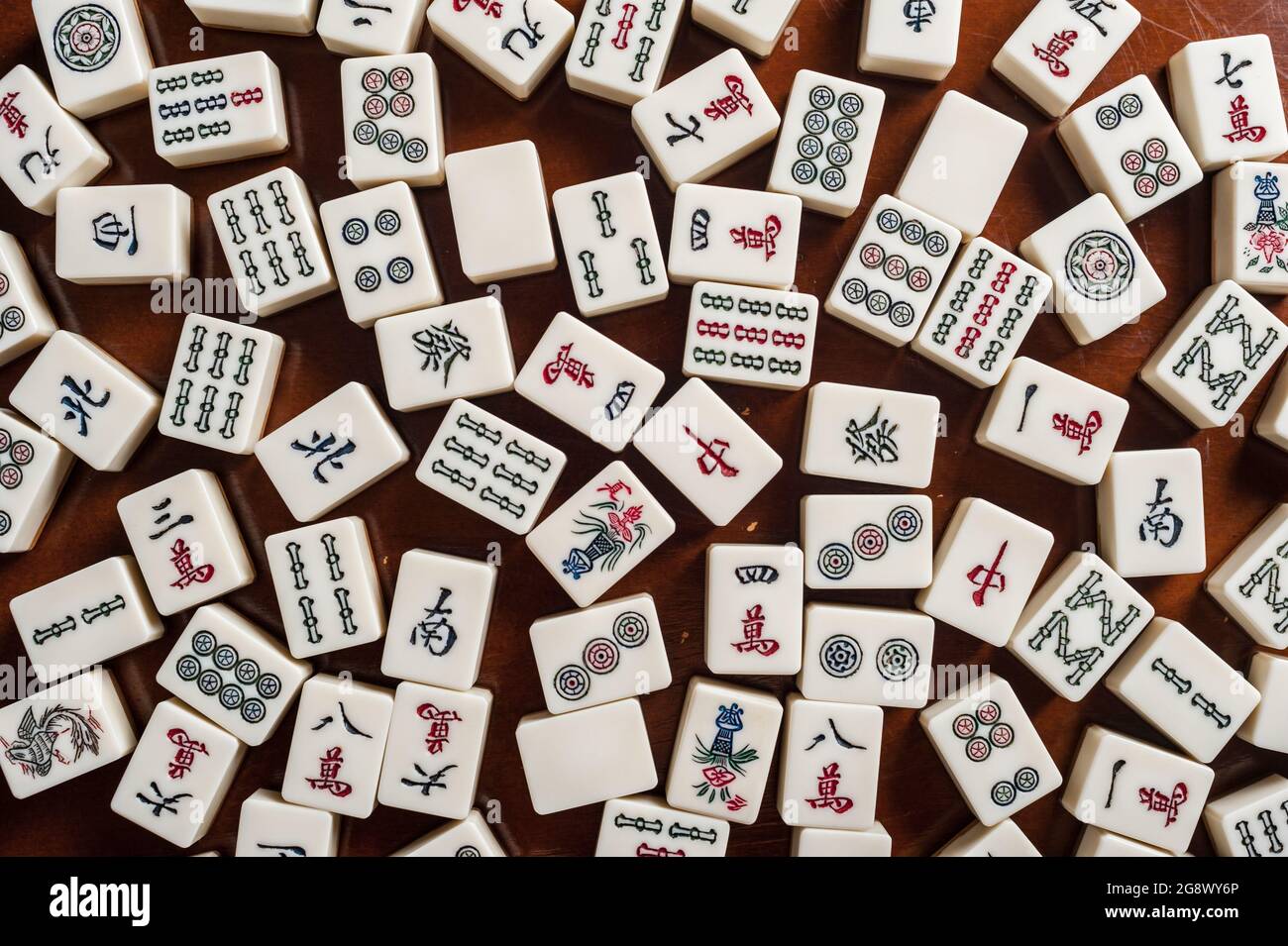 Many old mahjong tiles on wooden table. Mahjong is the ancient asian