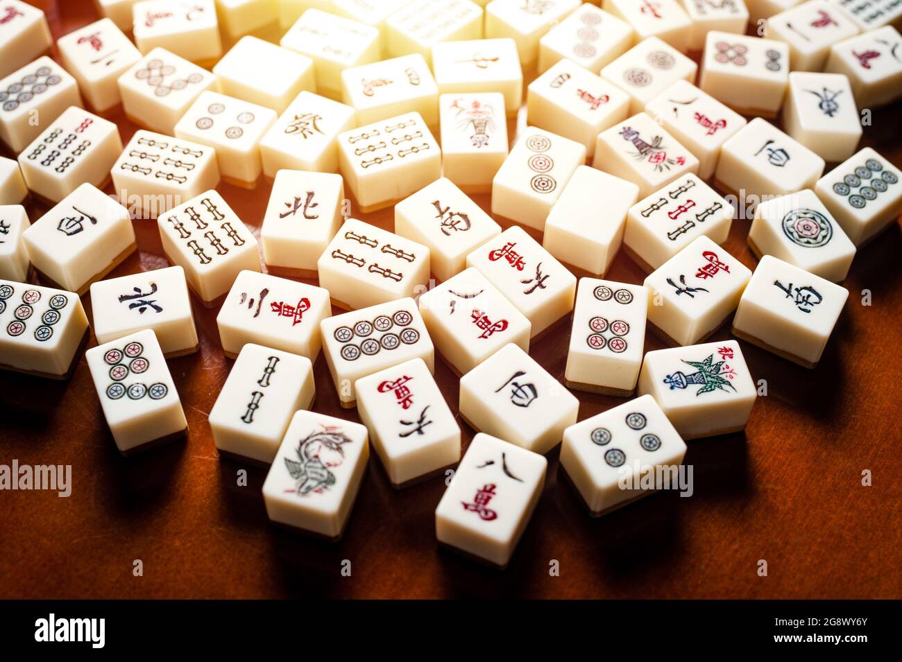 Many old mahjong tiles on wooden table. Mahjong is the ancient asian