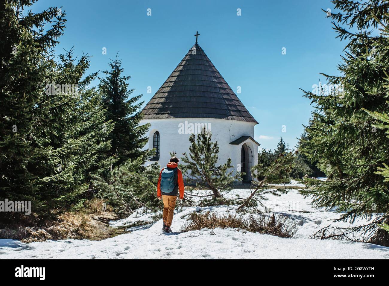 Backpacker at baroque Chapel of the Visitation of the Virgin Mary,Kunstat Chapel, located in Eagle Mountains at altitude of 1035 m, Czech Republic.Cir Stock Photo