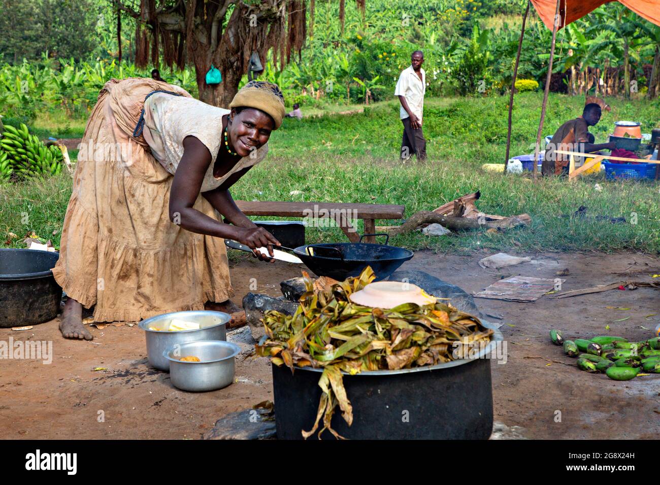 Local woman cooks banana dish known as Matooke, in Kitwa, Uganda Stock Photo