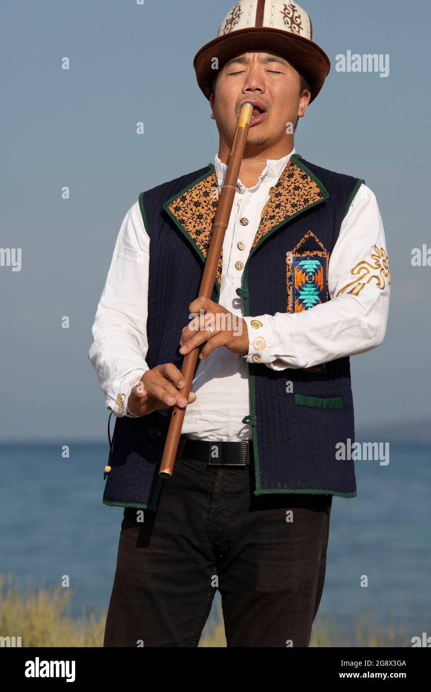 Kyrgyz musician playing traditional flute, in Issyk Kul, Kyrgyzstan. Stock Photo