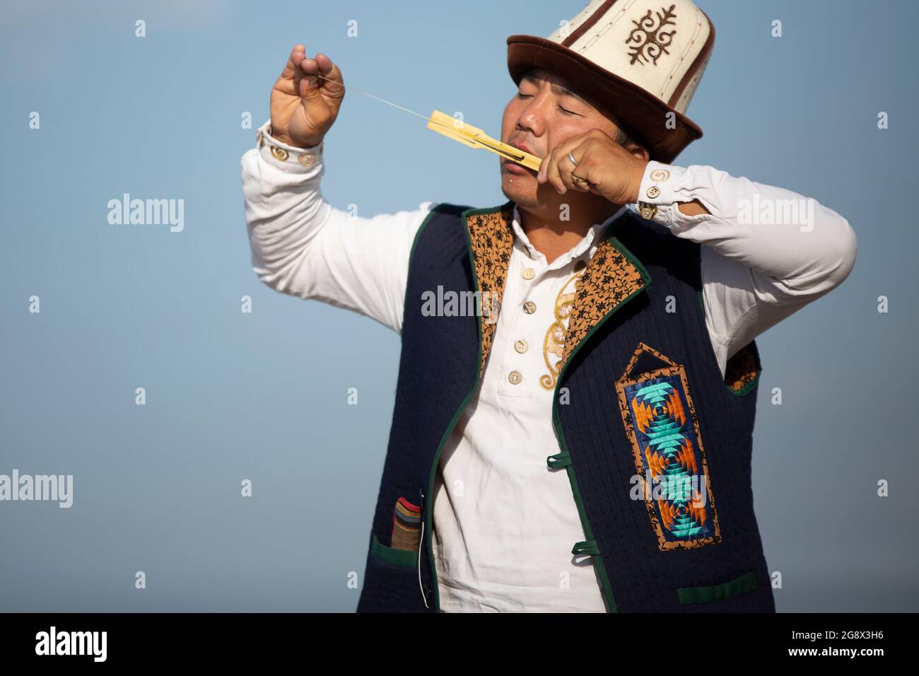 Kyrgyz musician playing local traditional instrument, in Issyk Kul, Kyrgyzstan. Stock Photo