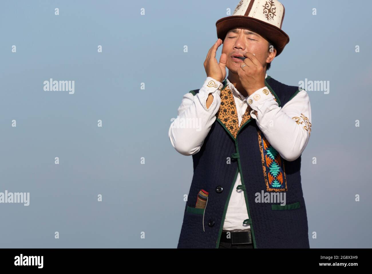 Kyrgyz musician playing traditional musical instrument known as Timur Komuz, a version of jaw's harp, in Issyk Kul, Kyrgyzstan Stock Photo