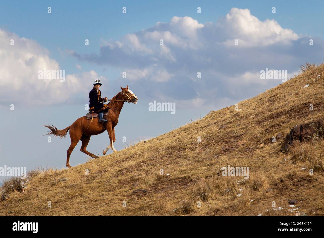 Nomadic man riding horse near Bishkek, Kyrgyzstan Stock Photo
