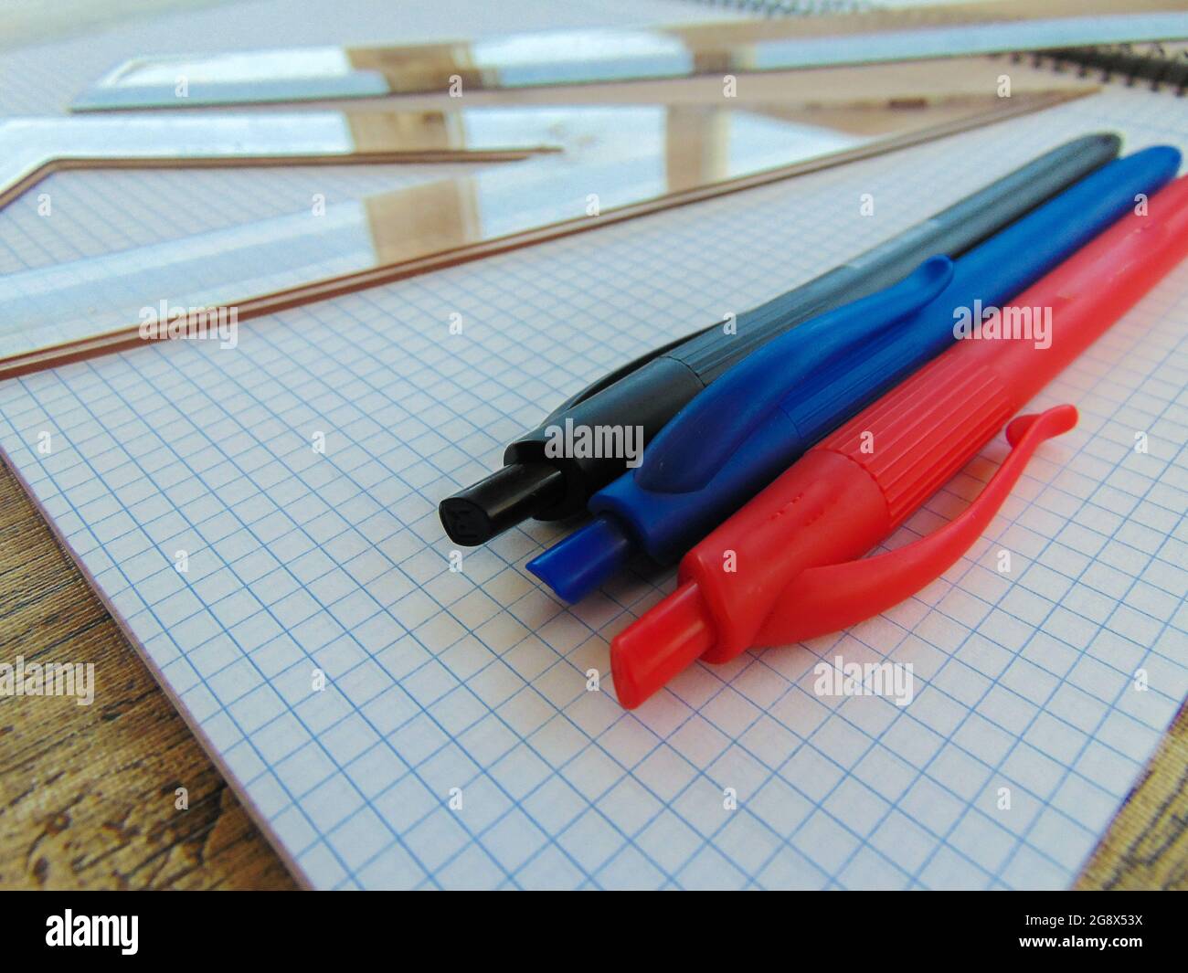 Close up of a table with student objects, pens, ruler, goniometer and note sheets Stock Photo