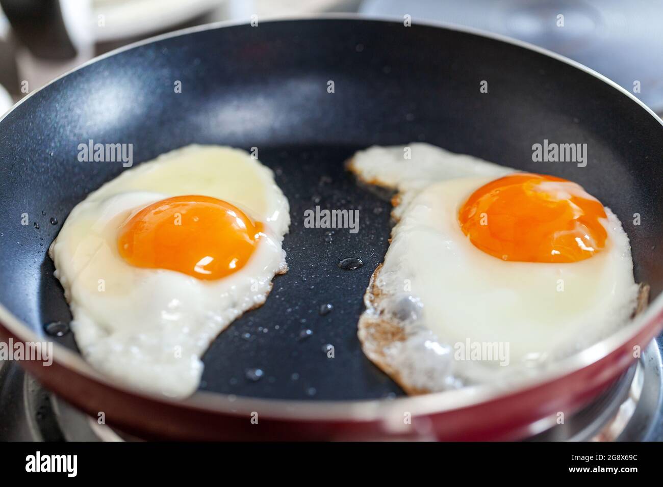 Breakfast getting ready. Sunny side fried eggs on the pan, closeup. Stock Photo