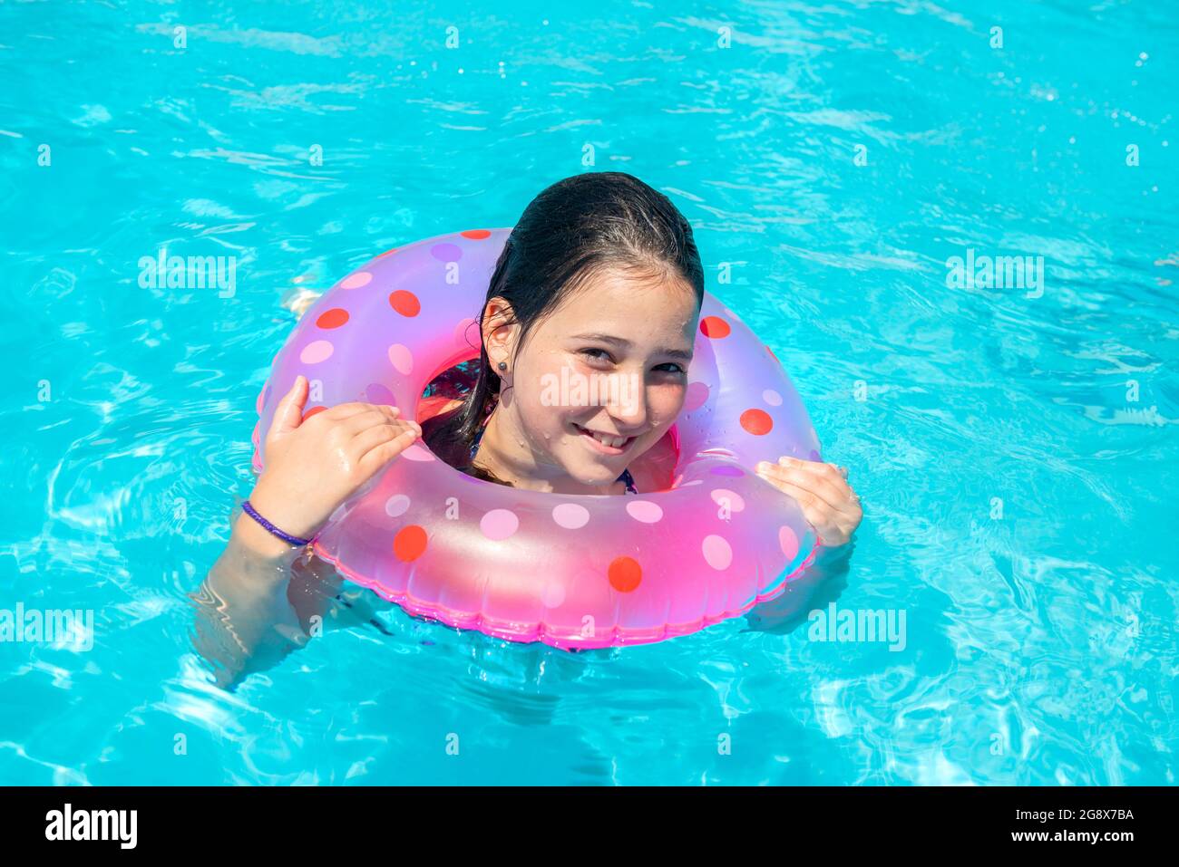 Beautiful young girl in a pool smilling Stock Photo