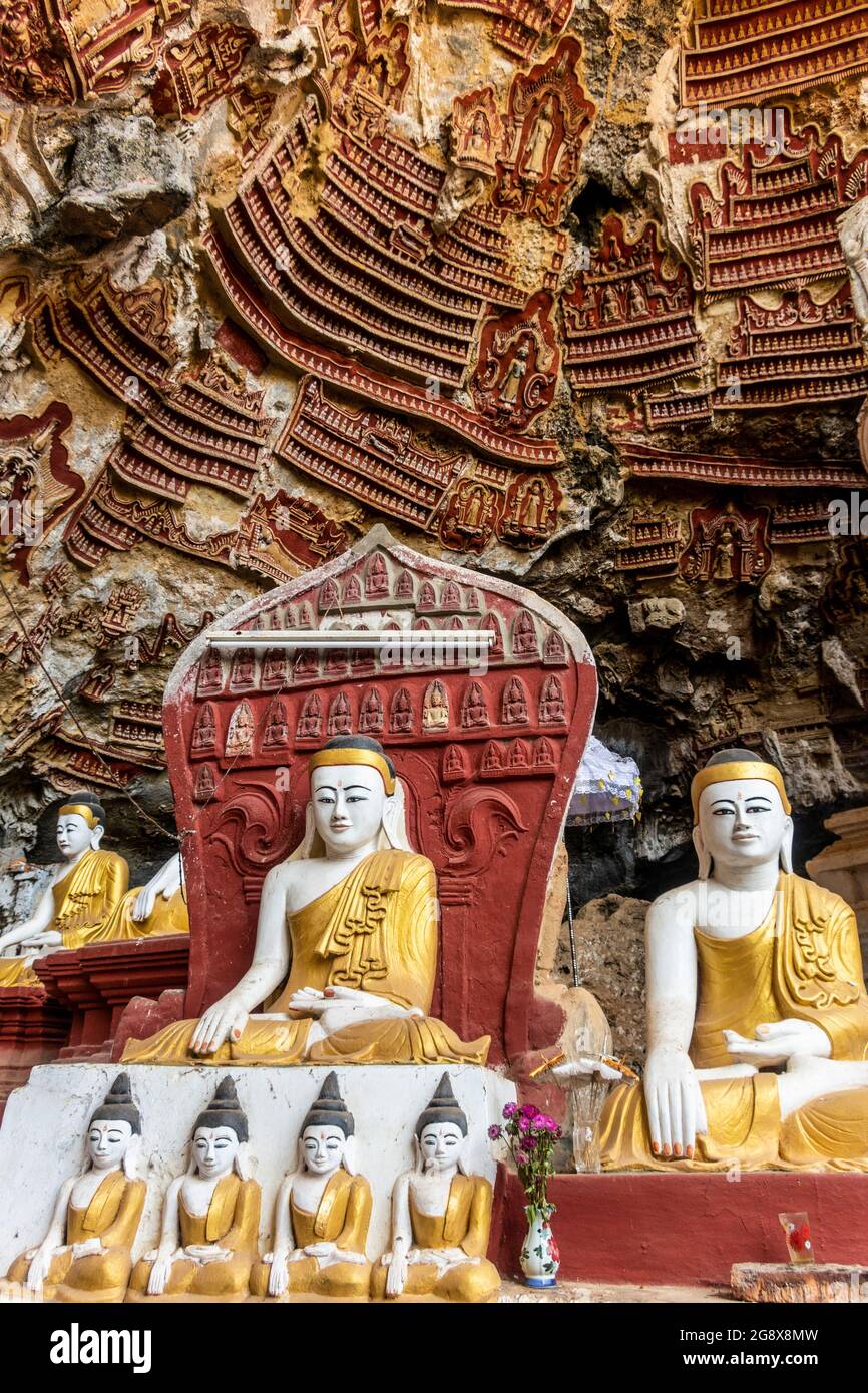 Old temple with Buddhas statues and religious carving on limestone rock in sacred Kaw Goon cave near Hpa-An in Myanmar Stock Photo