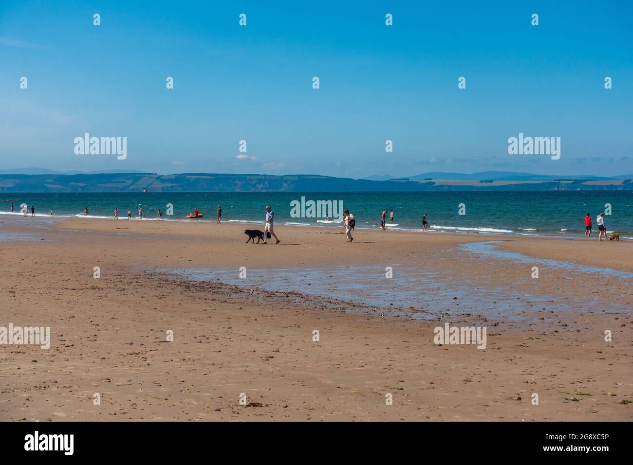 Sunbathers and swimmers on the beach at Nairn, Scotland, on a sunny summer day. Stock Photo