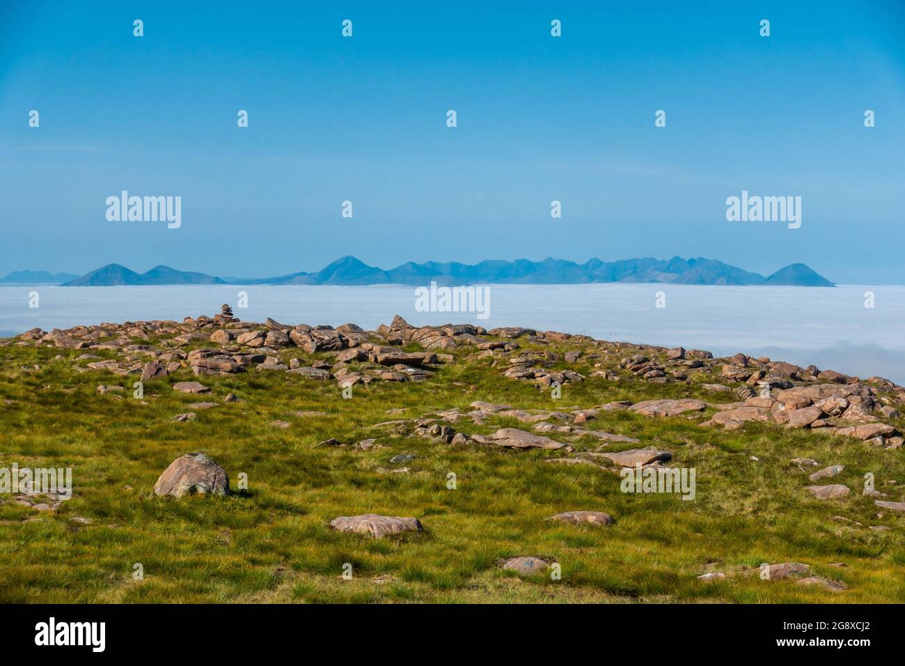 A cloud inversion of the distant Cuillin Ridge mountains on the Island of Skye, Scotland, seen from the summit of the Bealach Na Ba near Applecross Stock Photo