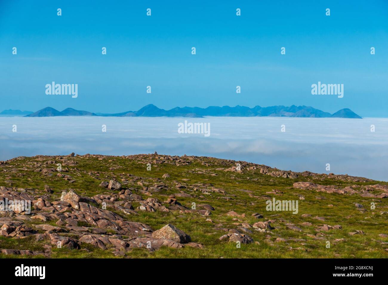 A cloud inversion of the distant Cuillin Ridge mountains on the Island of Skye, Scotland, seen from the summit of the Bealach Na Ba near Applecross Stock Photo