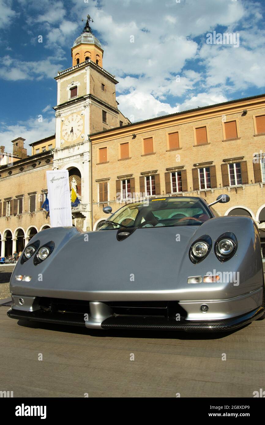 01-07-2021, Modena - Italy. Motor Valley Cars Exibition, gray Pagani Zonda in Piazza Grande with the city clock tower. Concept for italian style, luxu Stock Photo