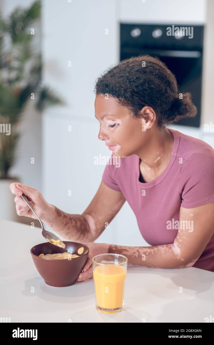 Dark-skinned young woman having breakfast at home Stock Photo