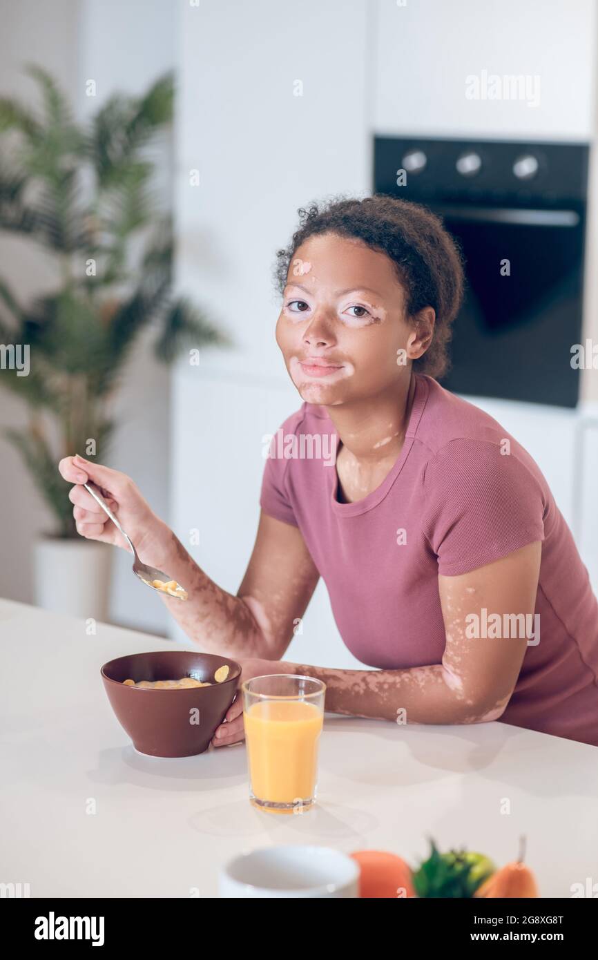 Dark-skinned young woman having breakfast at home Stock Photo