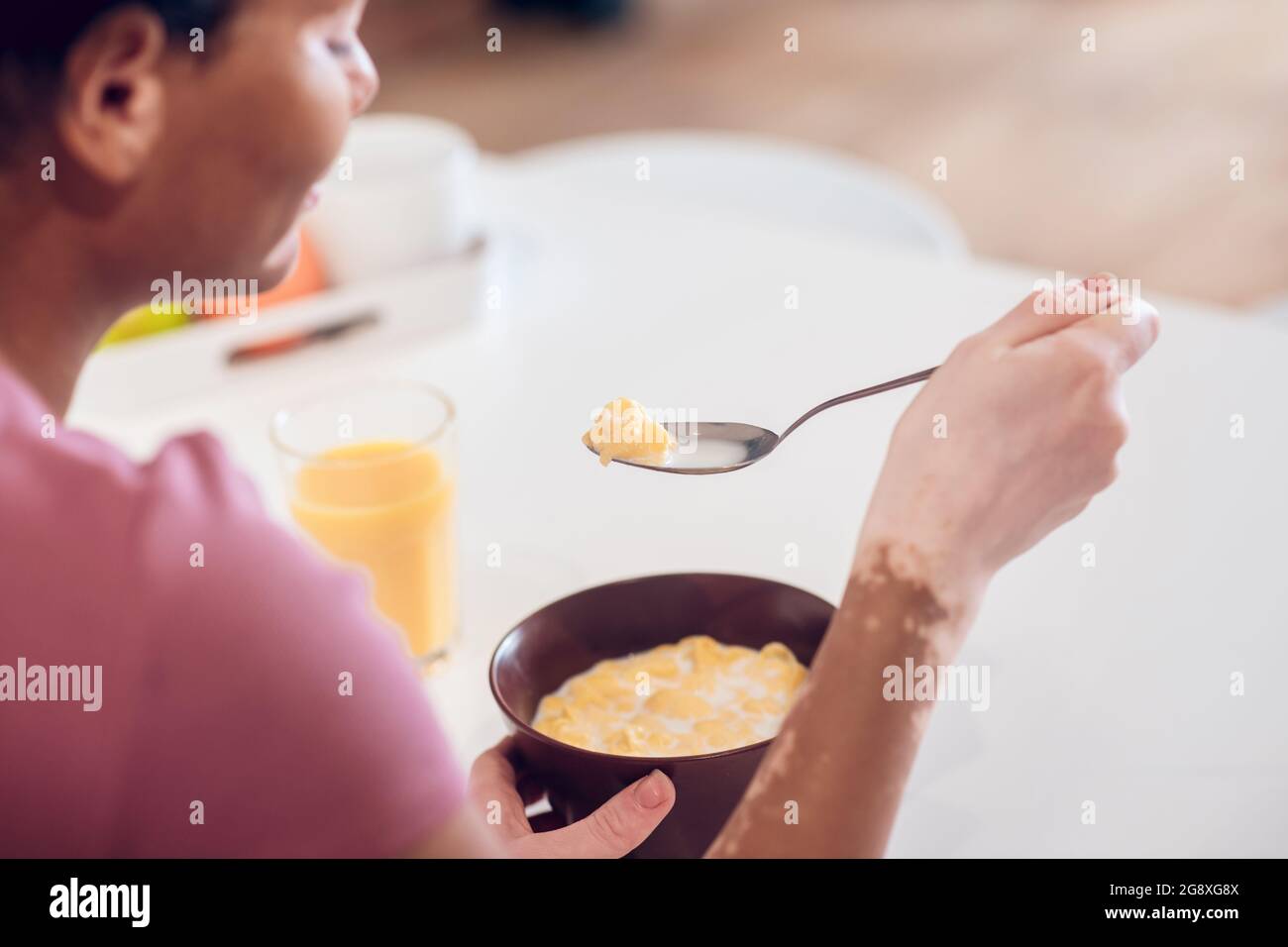 Dark-skinned young woman having breakfast at home Stock Photo