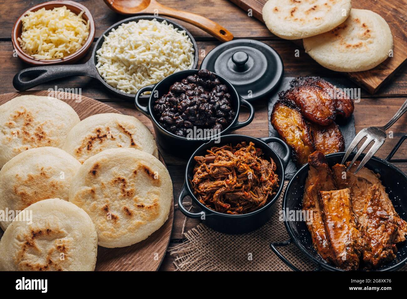 Table served with Venezuelan breakfast, arepas with different types of fillings such as black beans, shredded meat, fried plantain and cheese Stock Photo