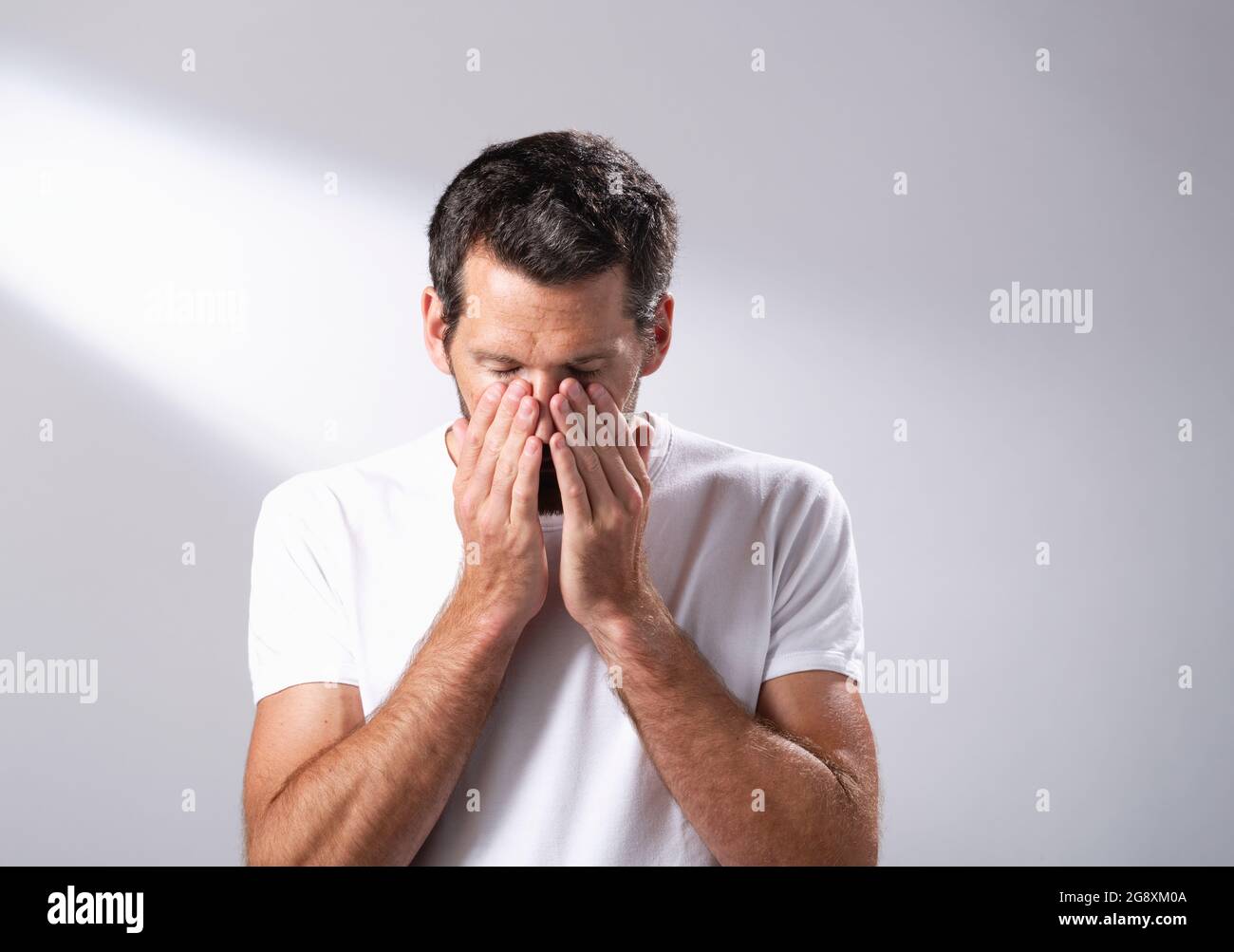 Man using a facial oil to massage in to his skin. Stock Photo