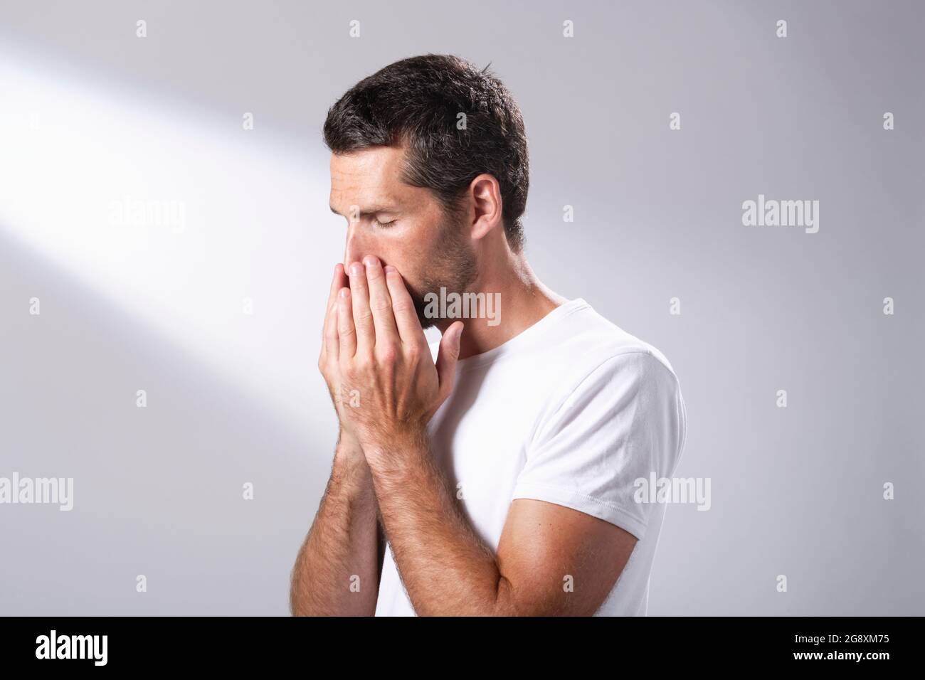 Man using a facial oil to massage in to his skin. Stock Photo