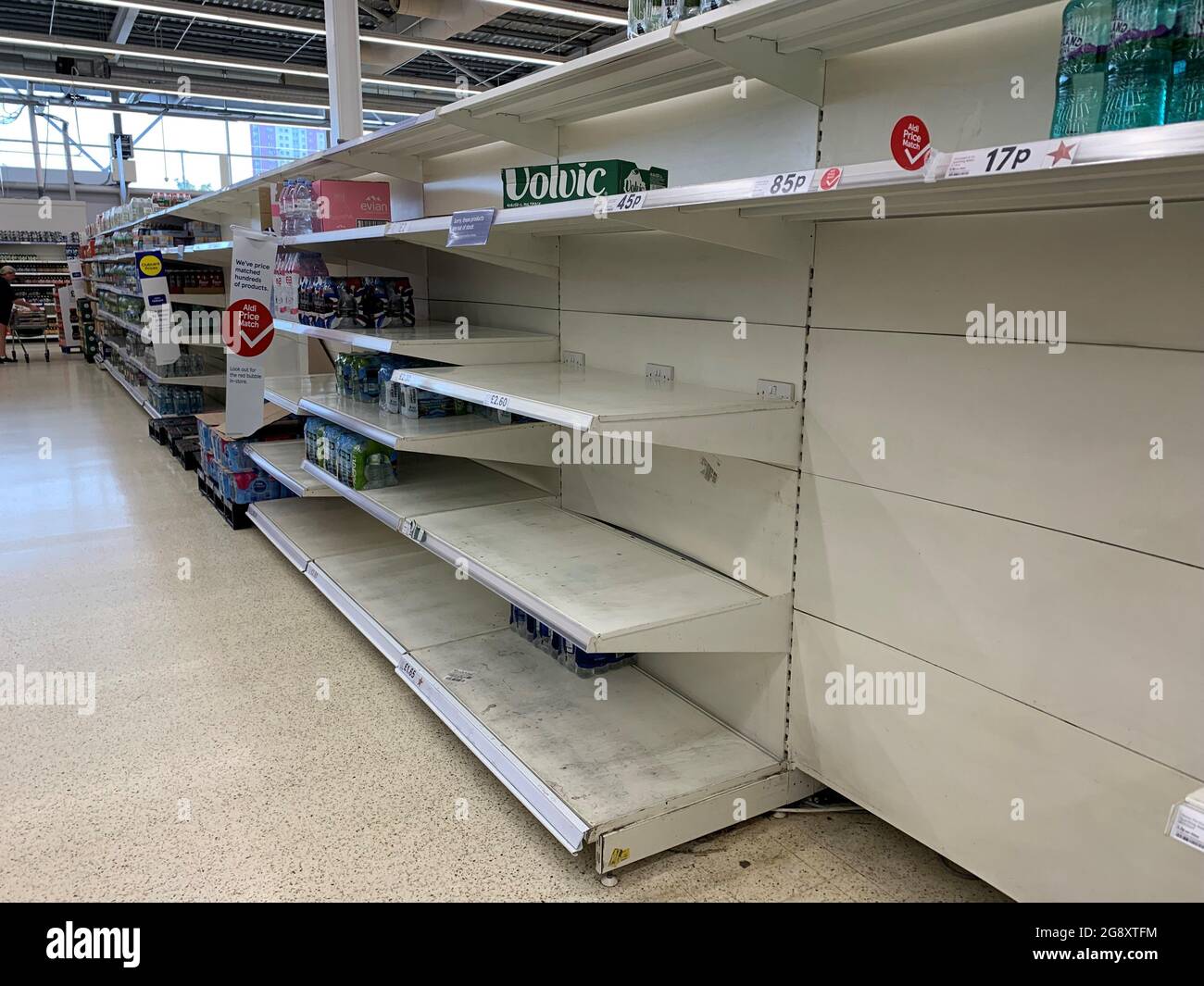 Empty shelves in the water aisle of the Tesco store at St Rollox in Glasgow. Pressure is mounting on the Government to bring forward the date at which people who are double vaccinated against coronavirus can avoid self-isolation as emergency measures to protect food supplies were launched on Thursday. Picture date: Friday July 23, 2021. Stock Photo