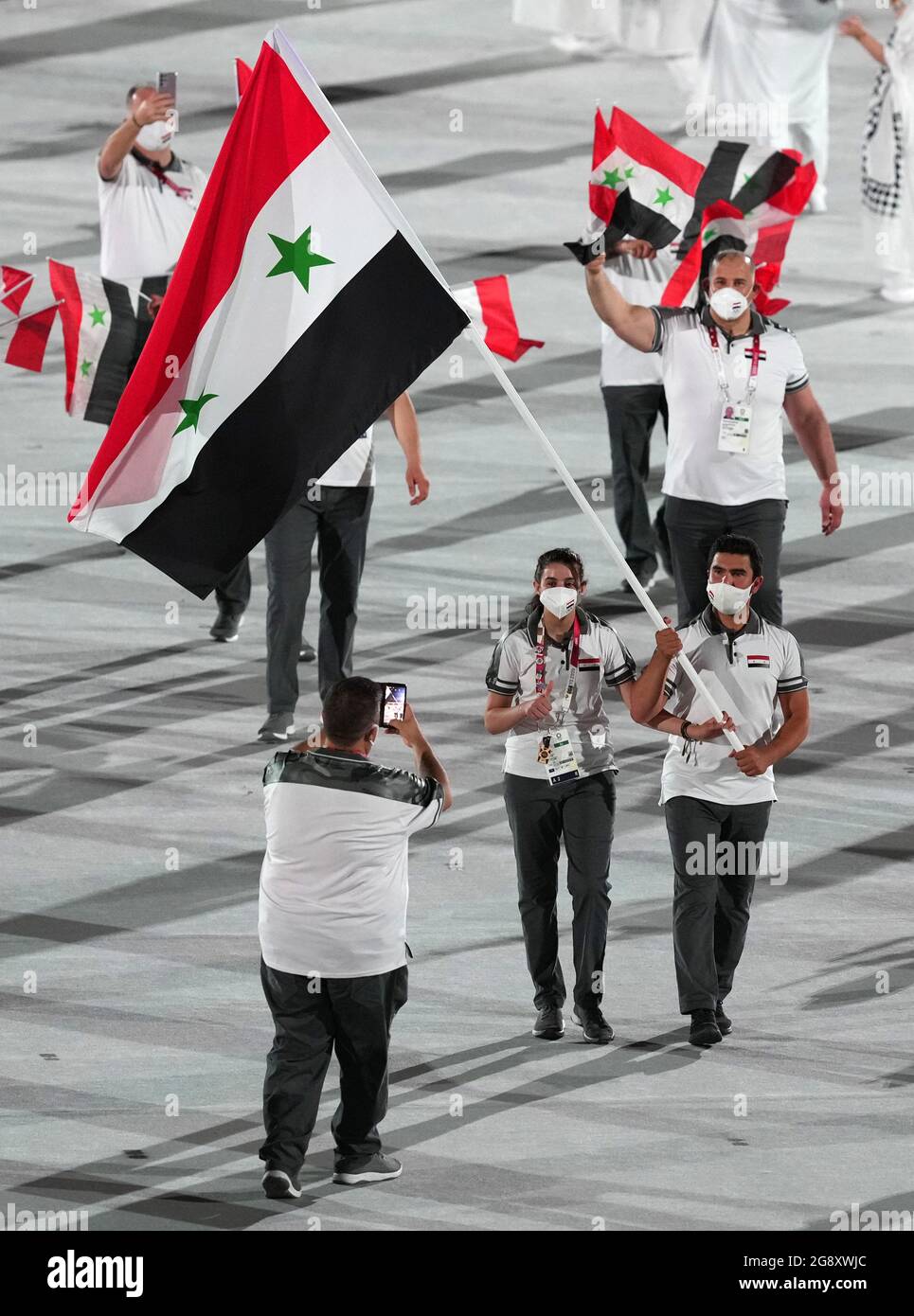 Syrian Arab Republic flagbearers Hend Zaza and Ahmad Saber Hamcho lead out the team during the opening ceremony of the Tokyo 2020 Olympic Games at the Olympic Stadium in Japan. Picture date: Friday July 23, 2021. Stock Photo