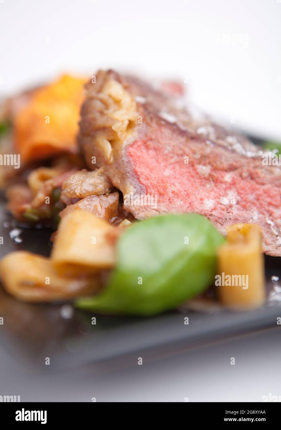 Rib-eye steak with penne pasta. Meat, gourmet lunch English cuisine. Stock Photo