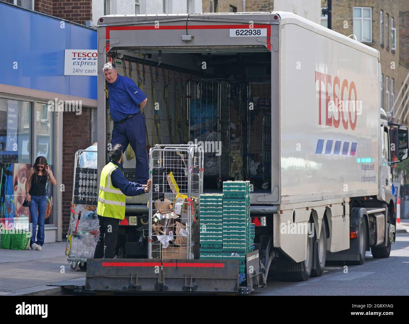 A delivery lorry outside a Tesco Express store in central London. Pressure is mounting on the Government to bring forward the date at which people who are double vaccinated against coronavirus can avoid self-isolation as emergency measures to protect food supplies were launched on Thursday. Picture date: Friday July 23, 2021. Stock Photo