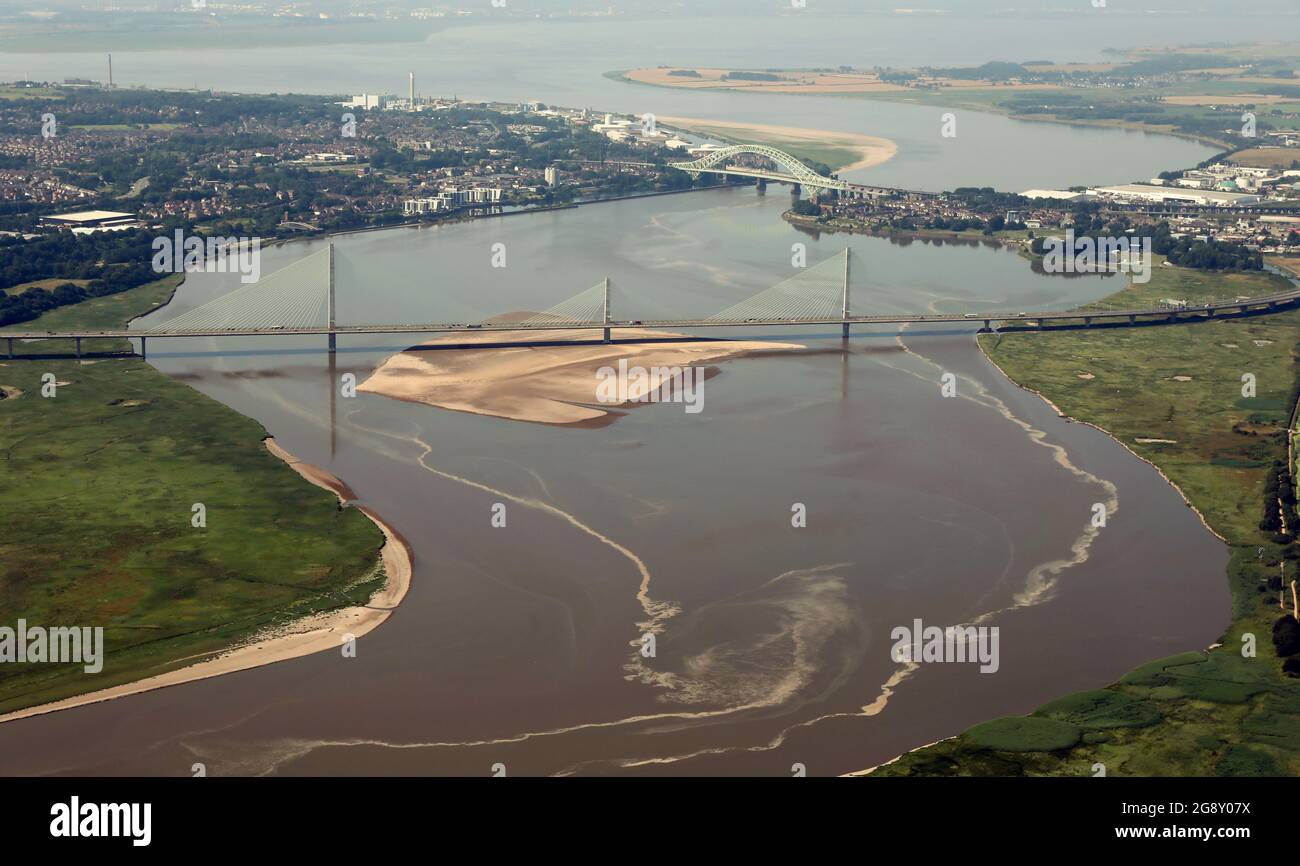 Aerial view of the two bridges that cross the Mersey from Runcorn. The Mersey Gateway in the foreground & the Silver Jubilee Bridge further back Stock Photo