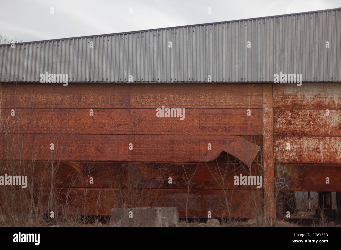 Abandoned warehousetype buildings. A rusty wall at a big house. The