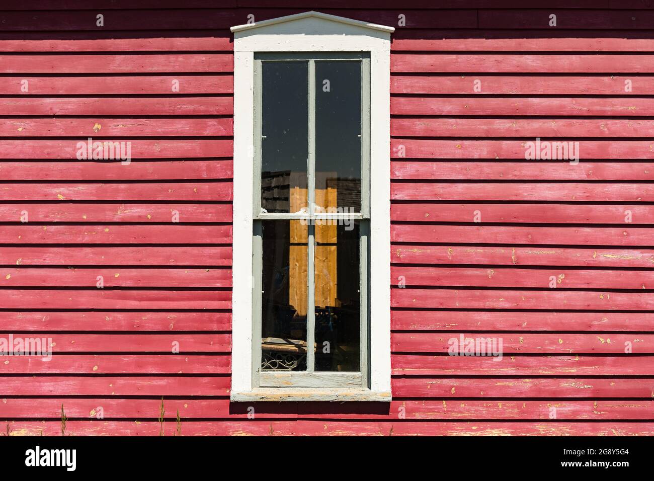 Exterior of old white painted window on bright red clapboard house Stock Photo