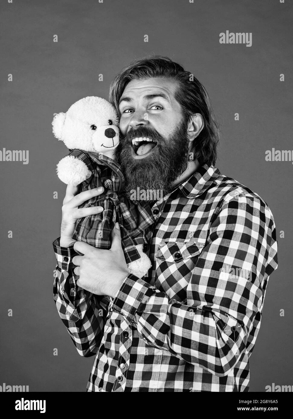 feel joy. cheerful bearded man hold teddy bear. male feel playful with bear. brutal mature hipster man play with toy. happy birthday. being in good Stock Photo