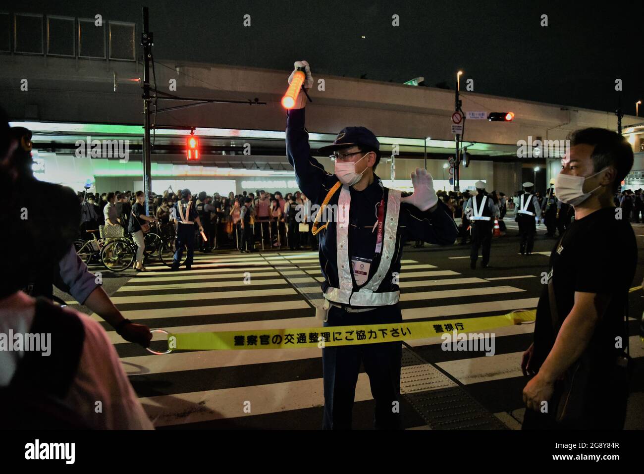 Tokyo, Japan - July 23, 2021 : Officers stands guard around Tokyo Olympics Stadium main street, a crowds during opening ceremony Tokyo 2020 Olympics Stock Photo