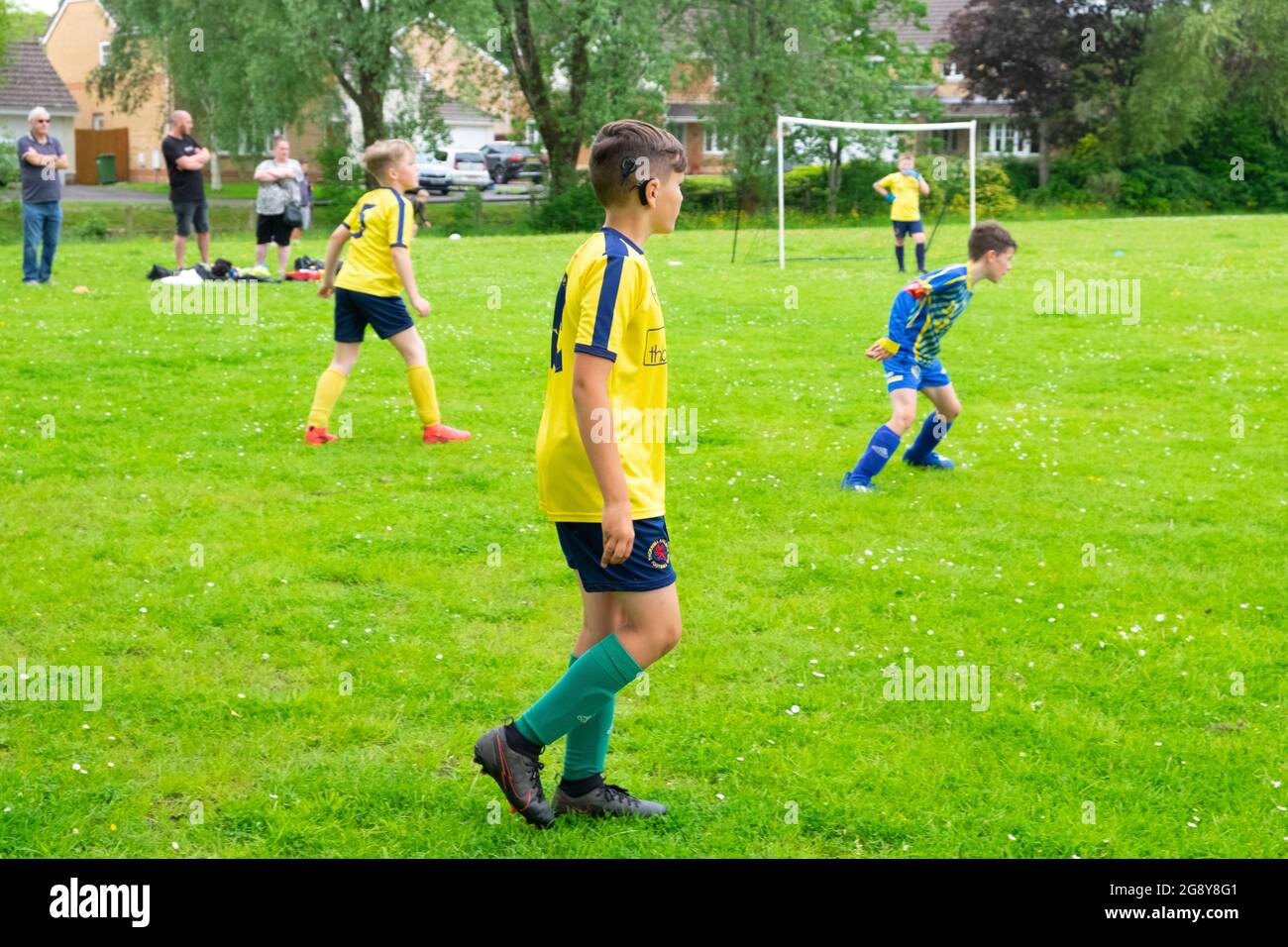 Boys teams and deaf boy child wearing cochlear implant playing football sport sports on Saturday morning in UK Great Britain  2021 KATHY DEWITT Stock Photo