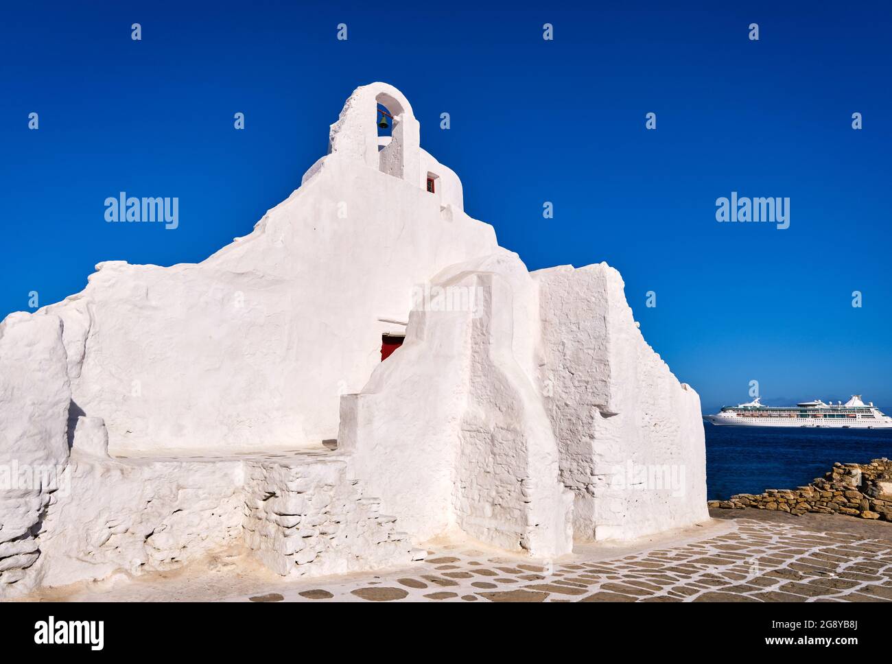 Famous tourist landmark, Mykonos, Greece. White Greek Orthodox church of Panagia Paraportiani, town of Chora on island at sunrise. Iconic destination Stock Photo