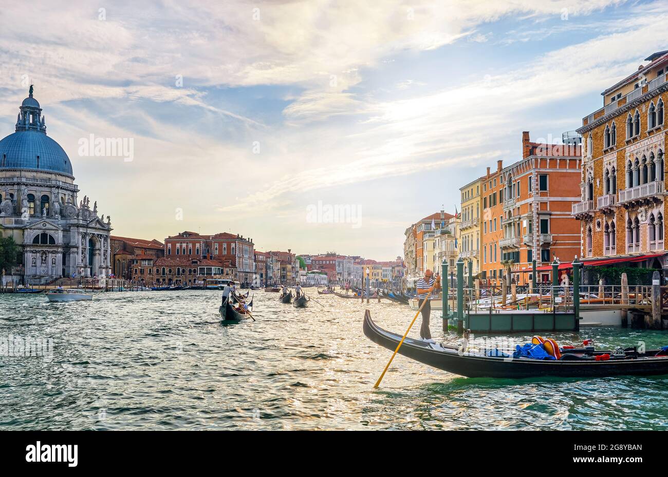 Romantic view of Grand Canal, Venice, Italy. Basilica di Santa Maria della Salute or St Mary of Health, colorful palaces by waterfront, many gondolas Stock Photo